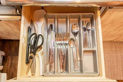 a drawer with silver utensils in a cabinet at Screamer 2 Hostel in Tokyo