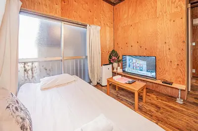 a bedroom with a bed and a flat screen tv at Screamer 2 Hostel in Tokyo