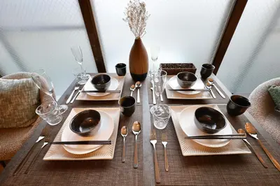 a table with plates and utensils and a vase at \u30b9\u30bf\u30fc\u30cf\u30a4\u30c4\u84b2\u7530301 in Tokyo