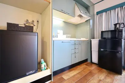 a small kitchen with a black refrigerator in a room at \u30b9\u30bf\u30fc\u30cf\u30a4\u30c4\u84b2\u7530301 in Tokyo