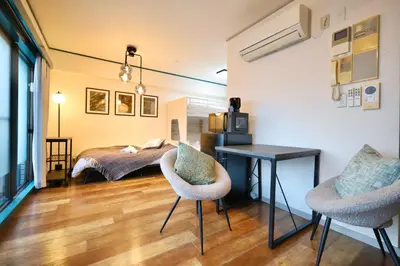 a bedroom with a bed and a desk and chairs at \u30b9\u30bf\u30fc\u30cf\u30a4\u30c4\u84b2\u7530301 in Tokyo