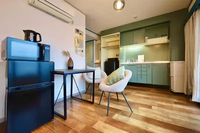 a kitchen with a black refrigerator and a table and chairs at \u30b9\u30bf\u30fc\u30cf\u30a4\u30c4\u84b2\u7530301 in Tokyo