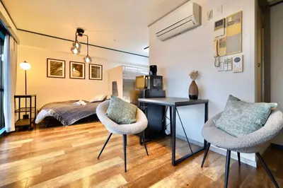 a bedroom with a bed and a desk and two chairs at \u30b9\u30bf\u30fc\u30cf\u30a4\u30c4\u84b2\u7530301 in Tokyo