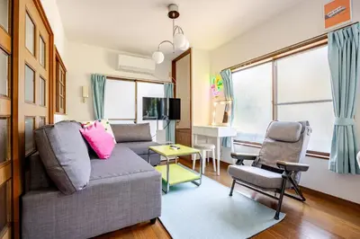 a living room with a couch and two chairs at Ohanachaya 3 Chome in Tokyo