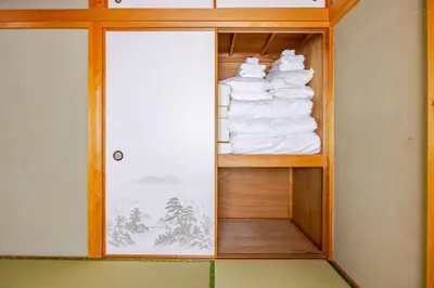 a wooden shelf with white towels in a room at Ohanachaya 3 Chome in Tokyo