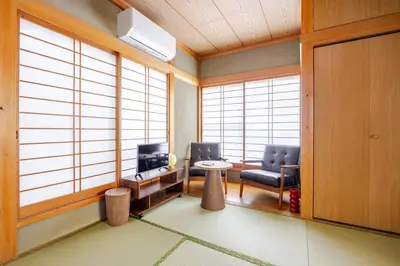 a room with two chairs and a tv and windows at Ohanachaya 3 Chome in Tokyo