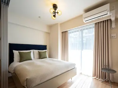 a bedroom with a bed and a large window at Section L Residence Shibuya in Tokyo