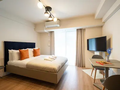 a bedroom with a bed and a desk and a television at Section L Residence Shibuya in Tokyo