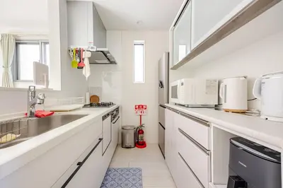 a white kitchen with white cabinets and a sink at Ikebukuro 3 Chome in Tokyo
