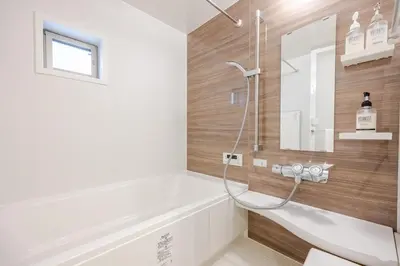 a bathroom with a tub and a shower with a mirror at Ikebukuro 3 Chome in Tokyo
