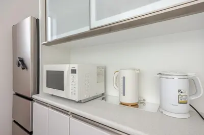 a kitchen counter with a microwave and appliances on it at Ikebukuro 3 Chome in Tokyo