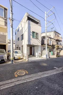 a white building on the side of a street at Ikebukuro 3 Chome in Tokyo
