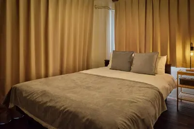 a bedroom with a large bed with curtains at asanagi in Tokyo