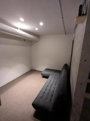 a room with a couch in the corner of a room at Family and Group stay, Private house close to Shinjuku in Tokyo