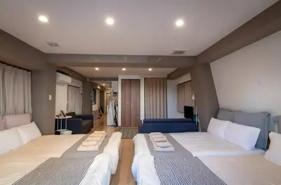a room with two beds and a living room at Daily Urban Lodge \u65b0\u5bbf\u30bc\u30f37 in Tokyo