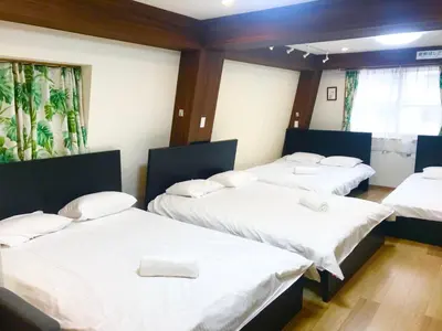 a room with three beds with white sheets at Daily Urban Lodge \u65b0\u5bbf\u30bc\u30f37 in Tokyo