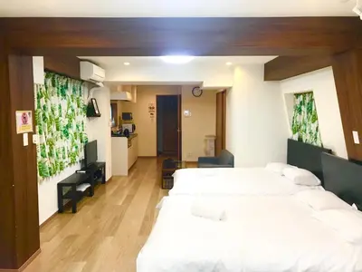 a room with three beds and a kitchen in it at Daily Urban Lodge \u65b0\u5bbf\u30bc\u30f37 in Tokyo