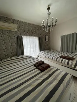 a bedroom with two beds and a chandelier at Yuri\u30d1\u30ec\u30b9\u65b0\u5bbf\u65b0\u5927\u4e45\u4fdd\u99c53\u5206 in Tokyo