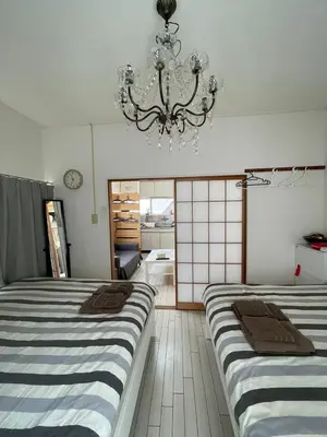 two beds in a room with a chandelier at Yuri\u30d1\u30ec\u30b9\u65b0\u5bbf\u65b0\u5927\u4e45\u4fdd\u99c53\u5206 in Tokyo