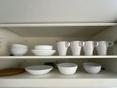 a shelf with white bowls and vases on it at Kichi in Tokyo
