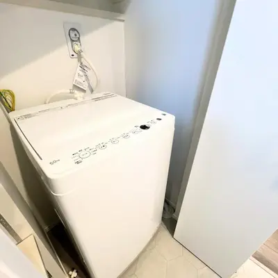 a white refrigerator in a kitchen with a sink at Kichi in Tokyo