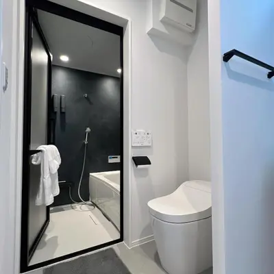 a bathroom with a toilet and a glass shower door at Kichi in Tokyo