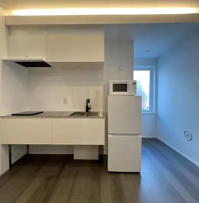 a white kitchen with a refrigerator and a microwave at Kichi in Tokyo