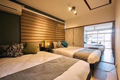 a hotel room with three beds and a window at NATURE BASE TOKYO Horikiri in Tokyo