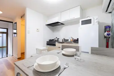 a kitchen with two white bowls on a table at Forest Guest House Shinjuku city center in Tokyo