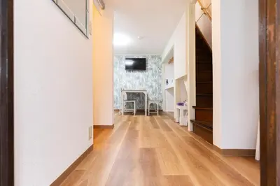 a hallway with wooden floors and white walls and a staircase at Forest Guest House Shinjuku city center in Tokyo