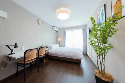 a hotel room with a bed and a table and chairs at \u3077\u3075\u304bTk\u6771\u5411\u5cf6302-1min to Higashi Mukojima Sta 3F Cozy Stay Near Skytree Asakusa in Tokyo