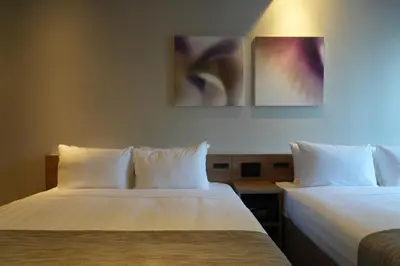 two beds sitting next to each other in a room at Premium Apart MONday GINZA EAST in Tokyo
