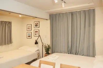 a bedroom with two beds and a window at Mi-HOTEL KAGURAZAKA in Tokyo