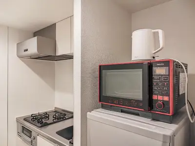 a microwave oven sitting on top of a refrigerator at Mi-HOTEL KAGURAZAKA in Tokyo