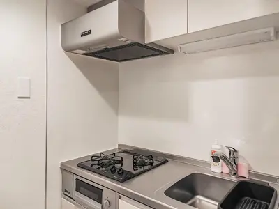 a kitchen with a stove and a sink at Mi-HOTEL KAGURAZAKA in Tokyo