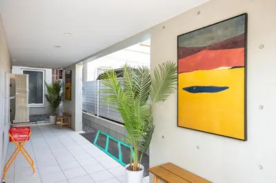 a painting on a wall in a hallway with a plant at Mi-HOTEL KAGURAZAKA in Tokyo