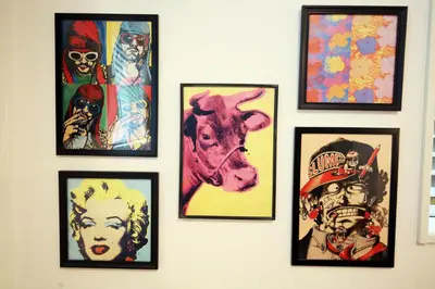 a group of framed pictures on a wall at HAMA HILLS Shinjuku House in Tokyo