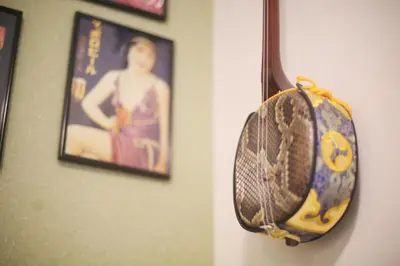 a baseball glove hanging on a wall with a picture at HAMA HILLS Shinjuku House in Tokyo