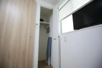 a room with a sliding door with a flat screen tv at HAMA HILLS Shinjuku House in Tokyo