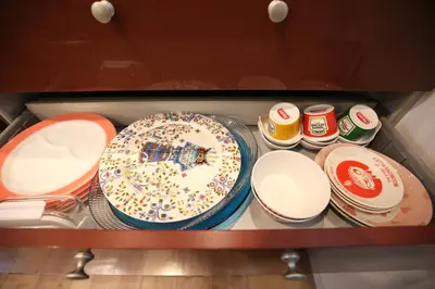 a drawer filled with plates and bowls and a cake at HAMA HILLS Shinjuku House in Tokyo
