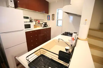 a kitchen with a sink with a dish rack in it at HAMA HILLS Shinjuku House in Tokyo