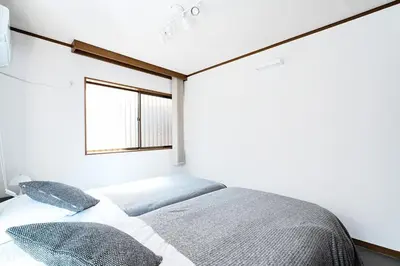 a bedroom with a bed and a window at Zen Sleep Tokyo Ikegami in Tokyo