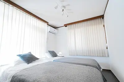 a bedroom with a bed and a large window at Zen Sleep Tokyo Ikegami in Tokyo