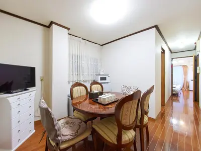 a dining room with a table and chairs and a television at Koka House TOKYO ASAKUSA in Tokyo