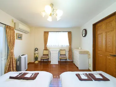 a bedroom with two beds and a window at Koka House TOKYO ASAKUSA in Tokyo