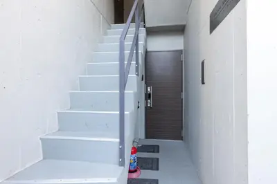 a hallway with white stairs and a wooden door at \u30e1\u30be\u30f3\u30a2\u30eb\u30c7\u30d0\u30e9\u30f3 in Tokyo
