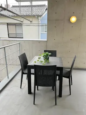 a black table with chairs and a vase of flowers on it at Sunshine in Tokyo