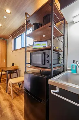 a kitchen with a black refrigerator and a table at Life Town Oshiage - Compact Stay - Steps from Skytree in Tokyo