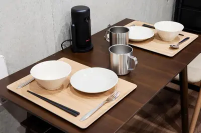 a wooden table with plates and utensils on it at Life Town Oshiage - Compact Stay - Steps from Skytree in Tokyo