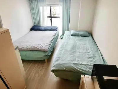two beds in a small room with a window at West Shinjuku Entire House with 2beds in Tokyo